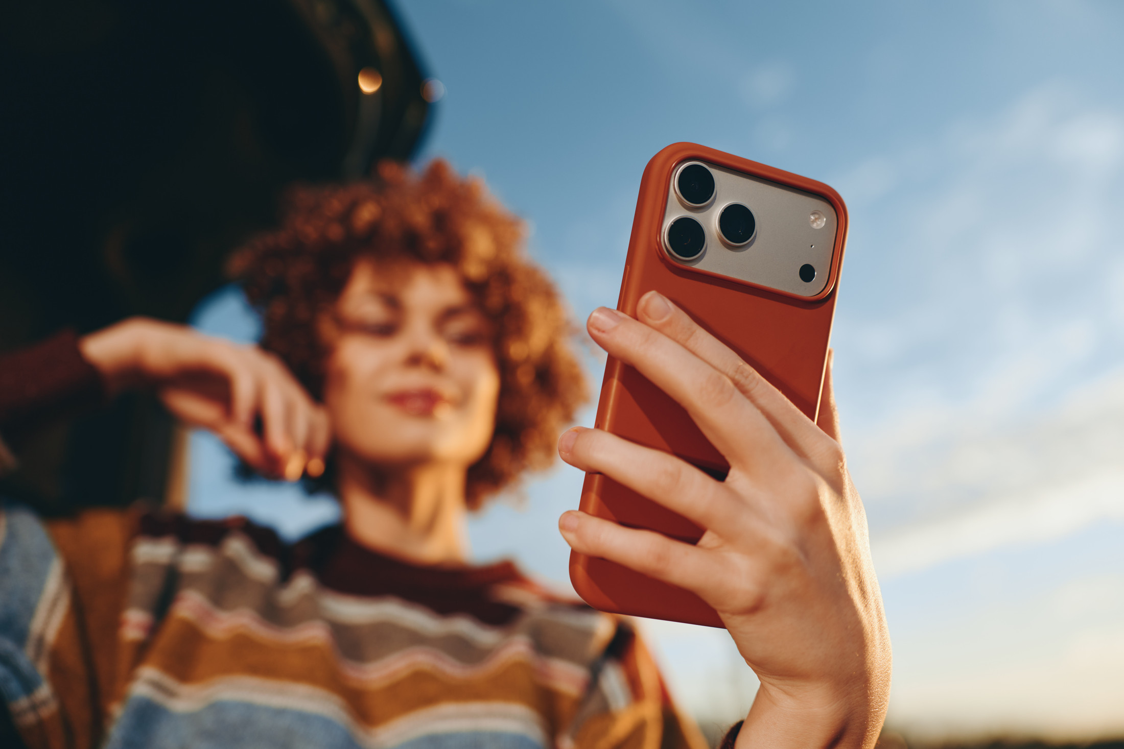 Creatorin mit Smartphone im Freien, aus einer dynamischen Perspektive aufgenommen